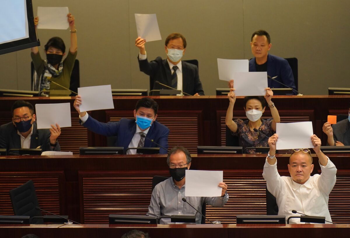 Pro-democracy lawmakers in the Legislative Council in Hong Kong raise white papers to protest the new national security law.