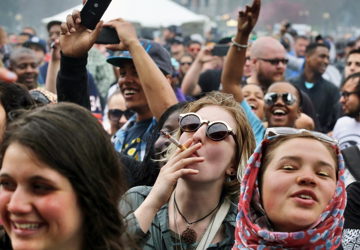 With the Colorado state capitol building visible in the background, party-goers dance to live music and smoke pot on the first of two days at the annual 4/20 marijuana festival in Denver on Saturday. The annual event is the first 420 marijuana celebration since retail marijuana stores began selling in January.