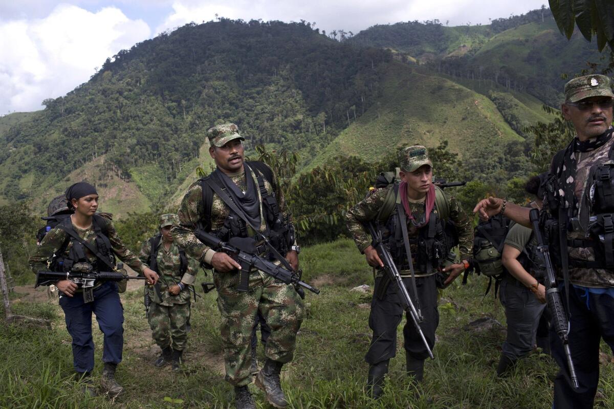 Juan Pablo, center, a commander of the Revolutionary Armed Forces of Colombia, or FARC, walks with his comrades in Antioquia state in January.