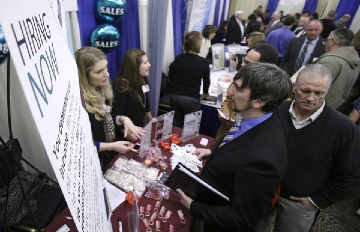 Job seekers talk with employers during a job fair this year in Cuyahoga Falls, Ohio.