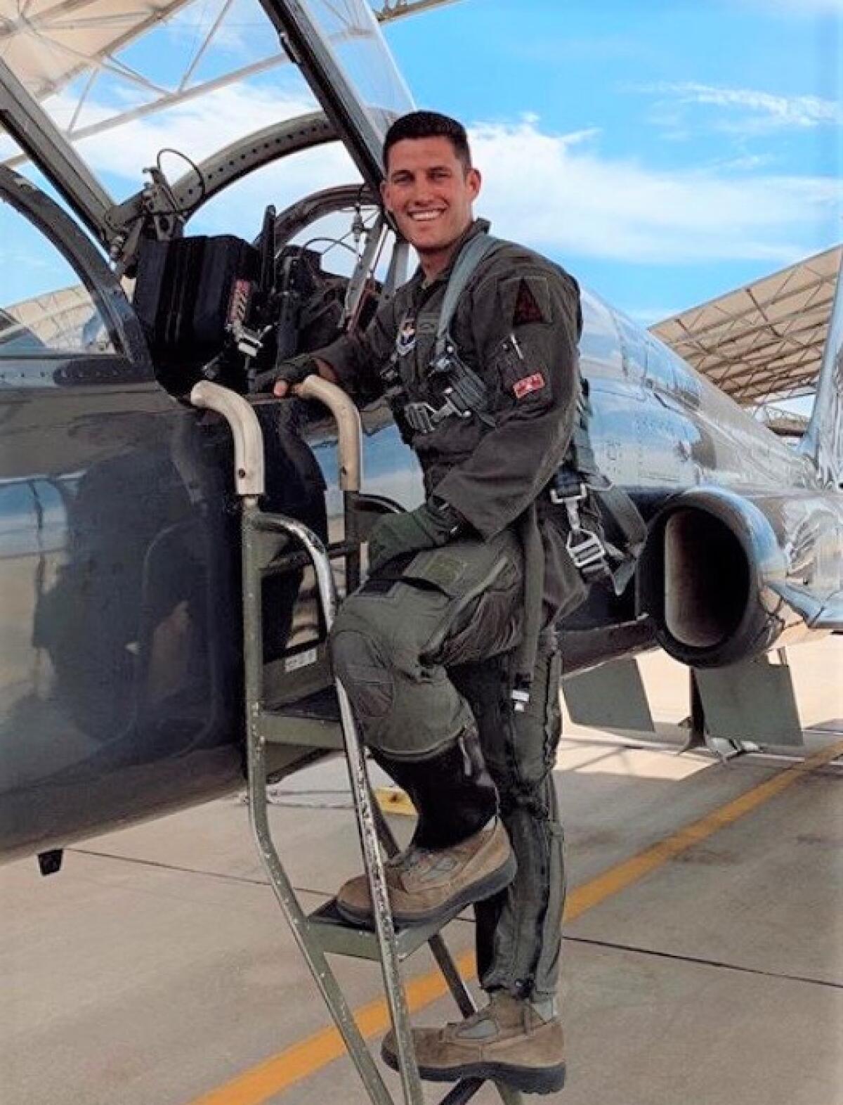 Air Force 2nd Lt. Travis Wilkie beside a T-34C Talon jet.