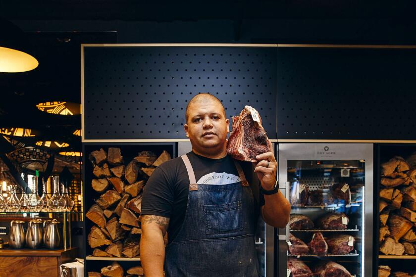 Trust Restaurant Group owner and chef Brad Wise holds a beef cut in his Wise Ox butcher shop.