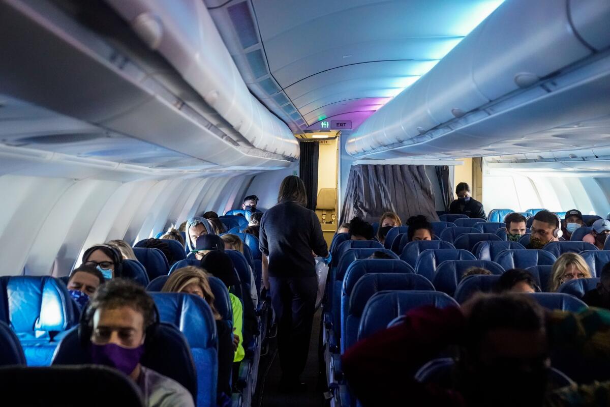 Masked passengers sitting on a flight.