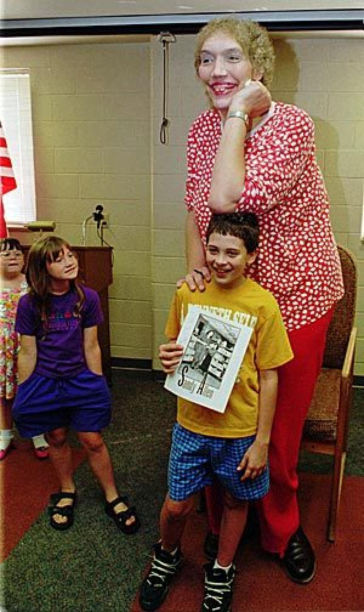 In this Sept. 2, 1995 file photo, Sandy Allen, poses for a picture with Will Denk, at the library in Shelbyville, Ind. The 7-foot-7 Allen considered the world's tallest woman died early today at a nursing home in her hometown of Shelbyville. She was 53.