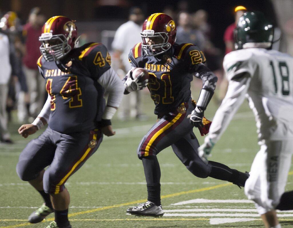 Estancia High's Jordan Alcazar (21) runs to the outside for a touchdown behind the blocking of Andy Martinez (44) against rival Costa Mesa on Friday.