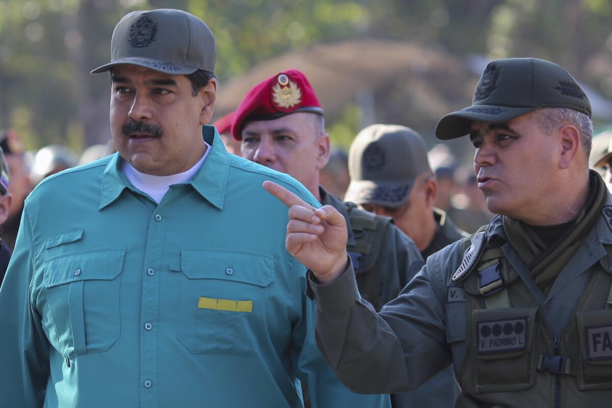 Handout picture released by the Venezuelan presidency showing Venezuela's President Nicolas Maduro (L) listening to Defence Minister Vladimir Padrino during military exercises at Fort Paramacay in Naguanagua, Carabobo State, Venezuela, on January 27, 2019. - Maduro on Sunday rejected a European ultimatum that he call elections as opposition rival Juan Guaido stepped up appeals to the military to turn against the leftist government.