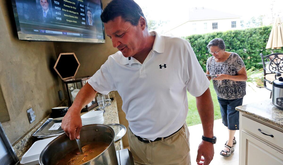 Ed Orgeron stirs the gumbo pot at his home in Mandeville, La., where the former USC assistant and interim coach spoke of a possible return to USC.