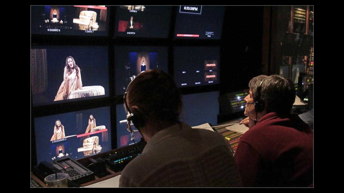 Matthew Diamond, right, conducts a dry run inside the control booth for the "La Traviata" simulcast.