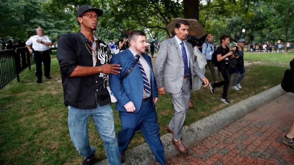 White nationalist Jason Kessler, center, and others depart after a rally near the White House on Sunday, the one-year anniversary of deadly violence at the Charlottesville, Va., "Unite the Right" rally.