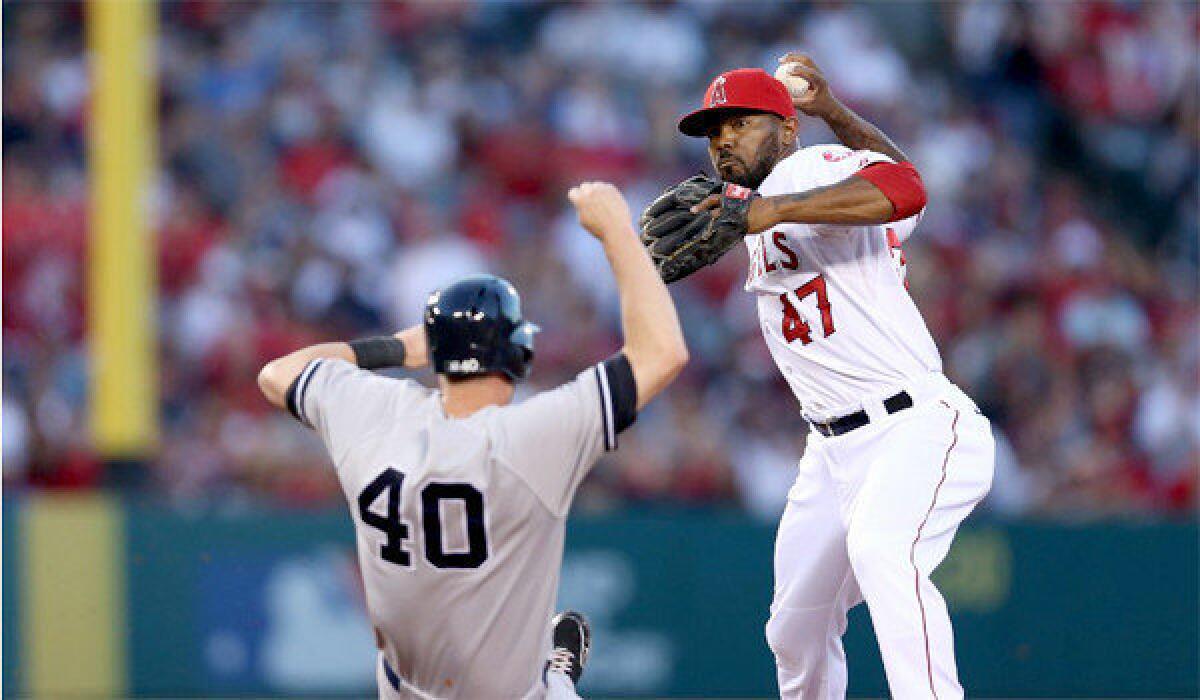 Howie Kendrick gets the force out on Reid Brignac at second before throwing to first to complete the double play in the fourth inning of the Angels' 5-2 victory over the New York Yankees on Friday.