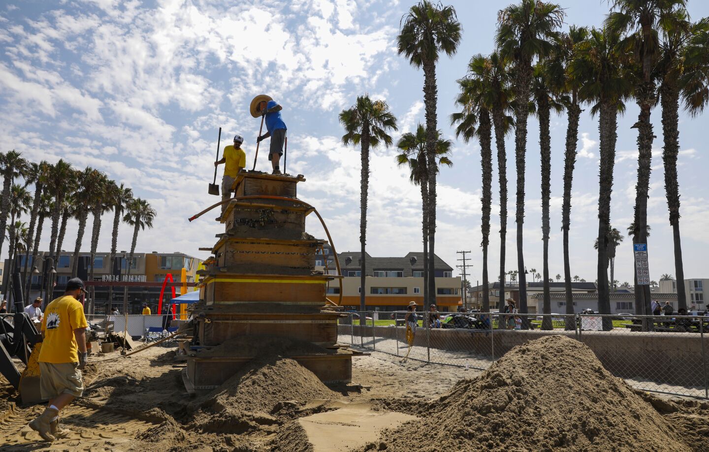 824931-sd-fi-sand-castle_NL August 14, 2021 San Diego, CA Imperial Beach's Sun & Sea Festival, an annual sandcastle event, is once again scaled down due to COVID. Today the festival highlighted that San Diego County's largest sandcastle competition was replaced by an effort to build the largest sandcastle ever on Imperial Beach sand. This massive sandcastle will be built at Portwood Pier Plaza by the multi-award-winning professional team and hometown favorite, I.B. Posse. Here, Leonard Gonzales, Jr. (left) and Bruce Phillips work atop of one of two structures which they are hoping to finish by Wednesday. © 2021 Nancee Lewis / Nancee Lewis Photography