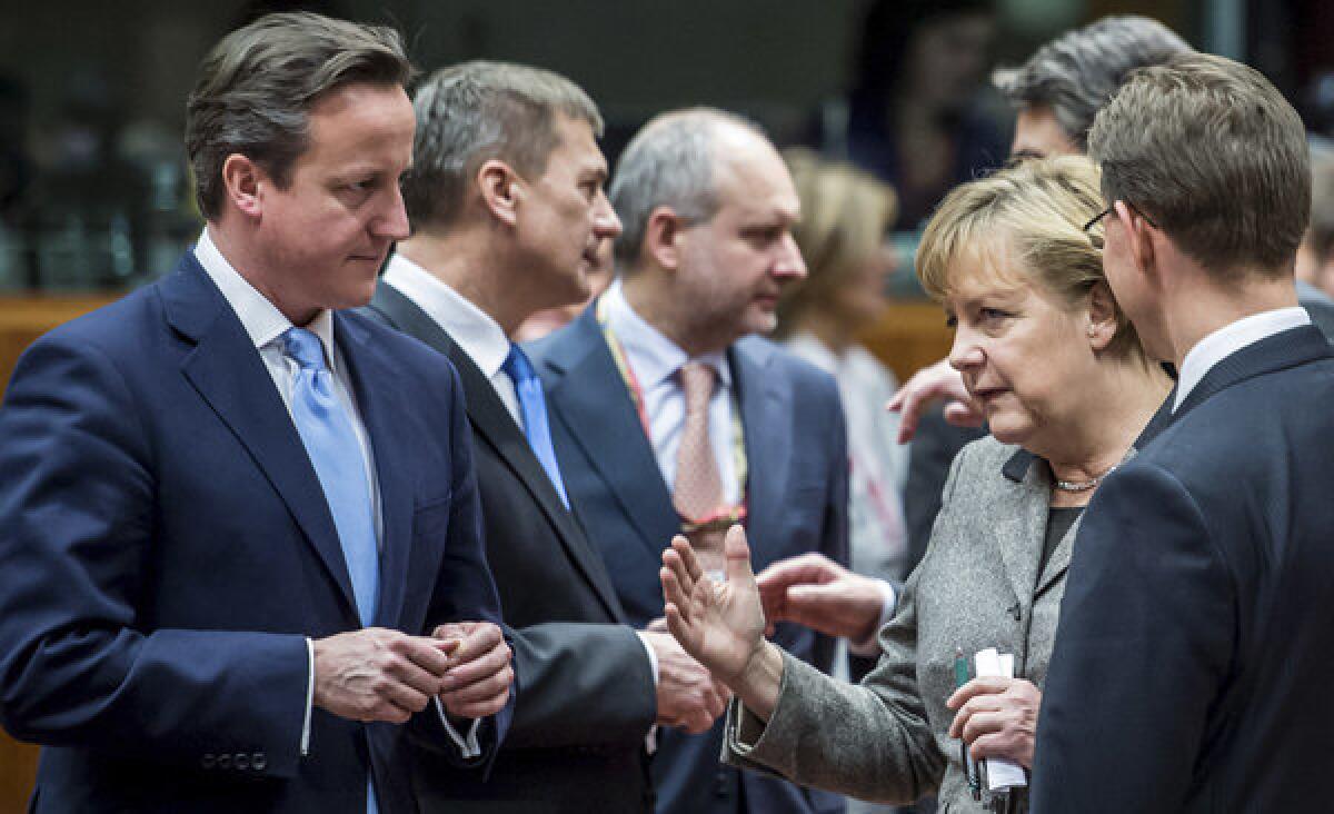British Prime Minister David Cameron, left, speaks with Finland's prime minister, Jyrki Tapani Katainen, right, and German Chancellor Angela Merkel, second right, during a round-table meeting at a European Union gathering in Brussels.