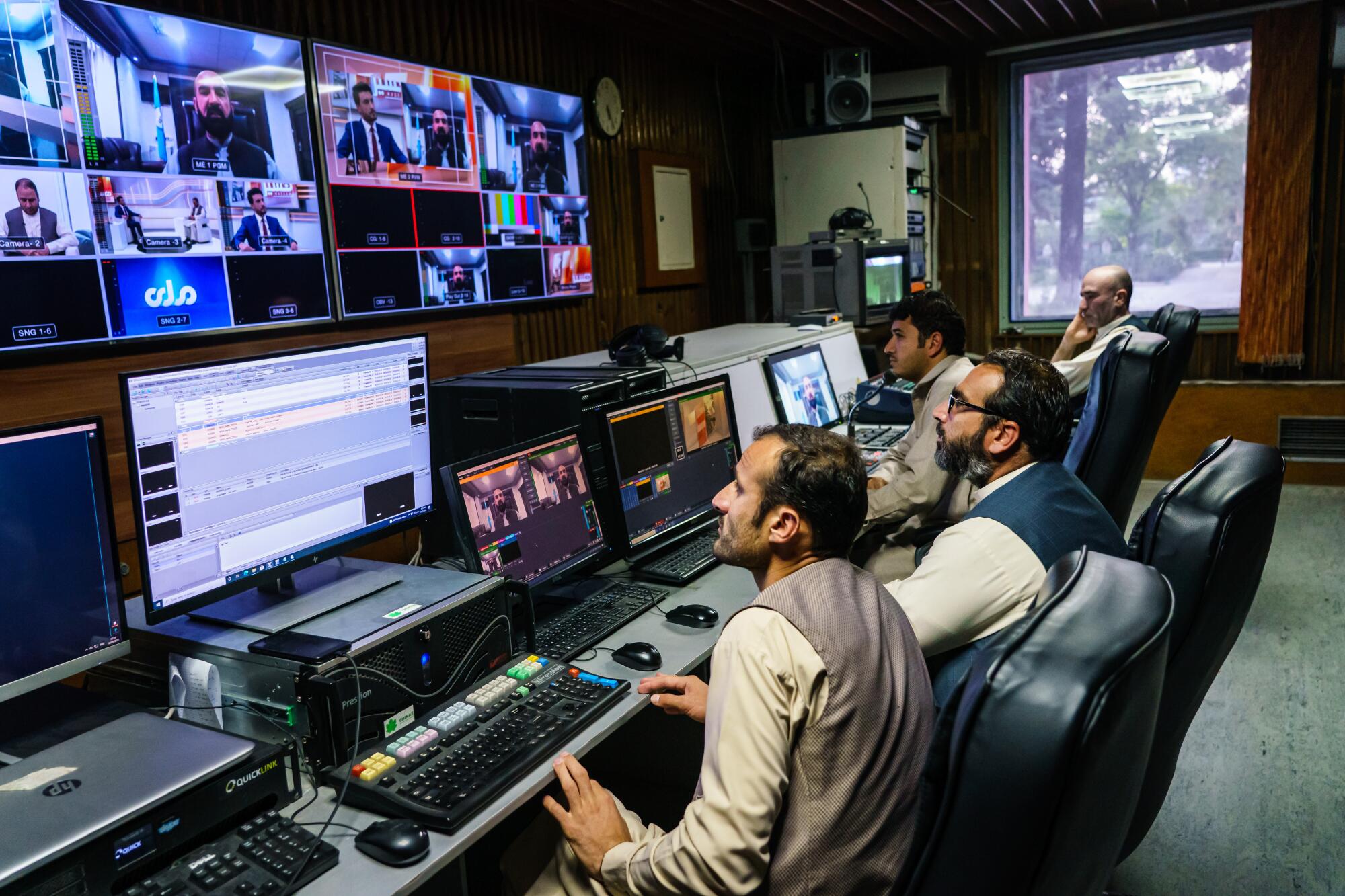 Workers looking up at a bank of TV screens