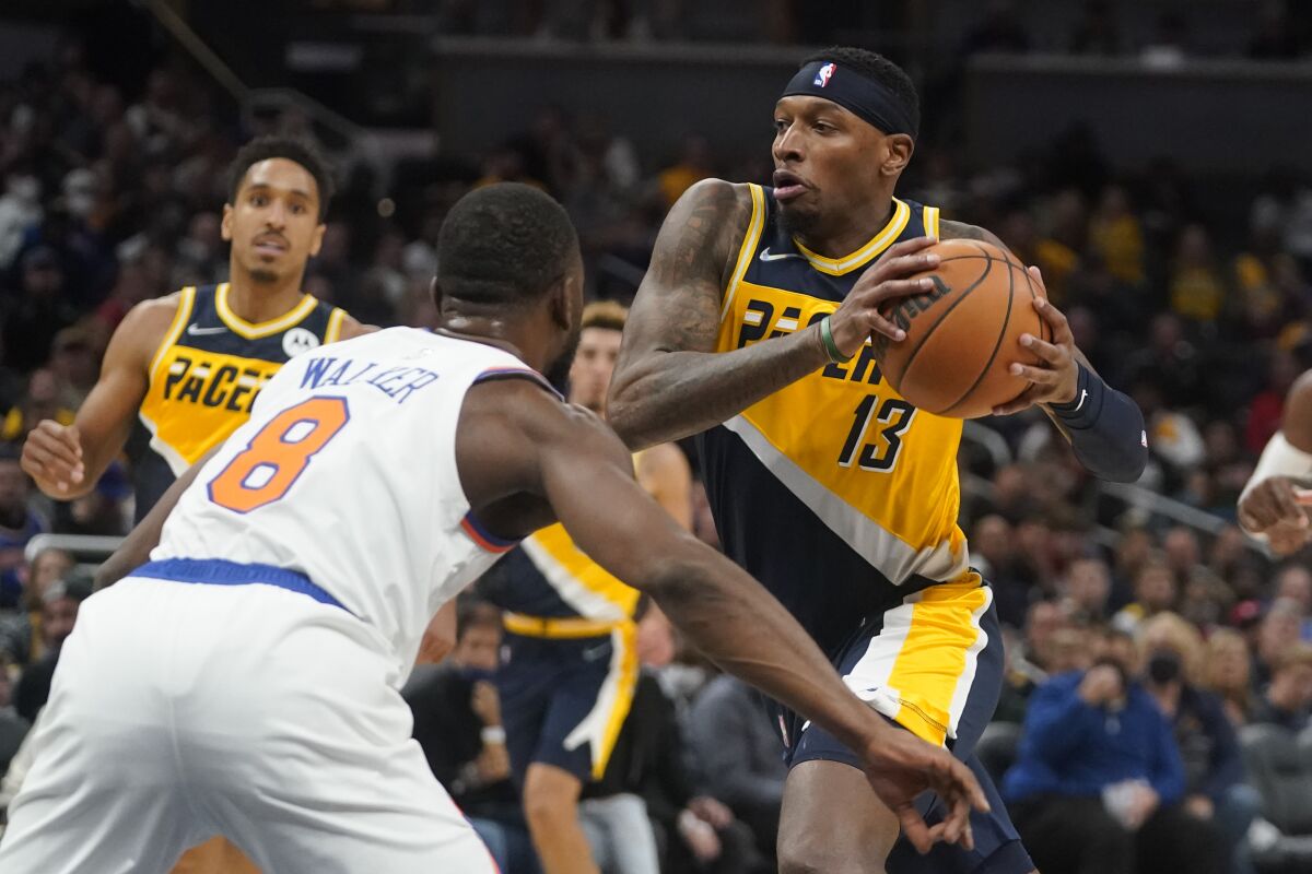 Indiana Pacers' Torrey Craig (13) goes to the basket against New York Knicks' Kemba Walker (8) during the second half of an NBA basketball game Wednesday, Nov. 3, 2021, in Indianapolis. Indiana won 111-98. (AP Photo/Darron Cummings)