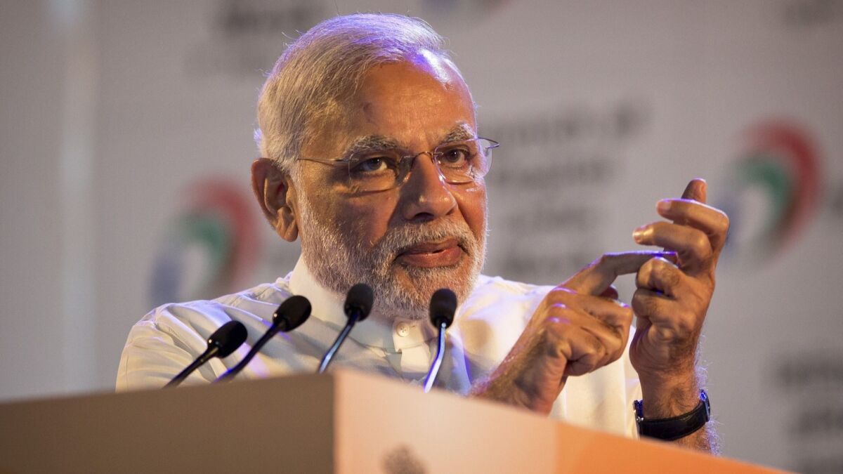Indian Prime Minister Narendra Modi gestures with a cell phone during the launch of a digital India project in 2015.