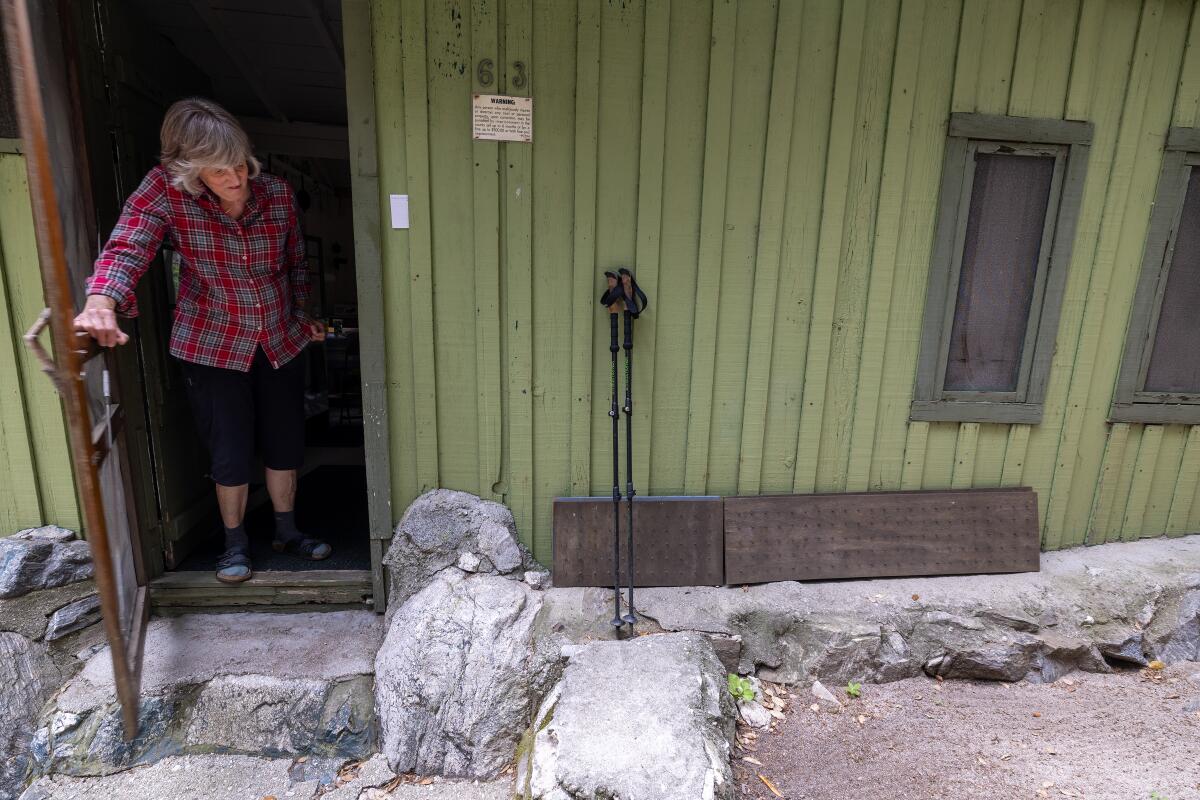  Joanie Kasten opens the front door to her small cabin in the Big Santa Anita Canyon.