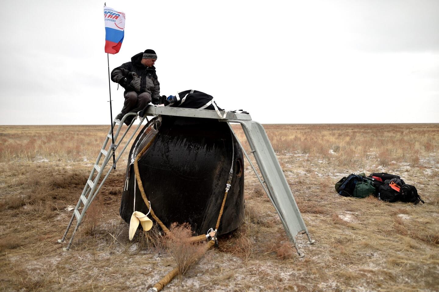 A member of the search and rescue team works at the site of landing of the Soyuz TMA-18M space capsule carrying the International Space Station (ISS) crew of US astronaut Scott Kelly and Russian cosmonauts Mikhail Kornienko and Sergei Volkov near the town of Dzhezkazgan (Zhezkazgan), Kazakhstan.