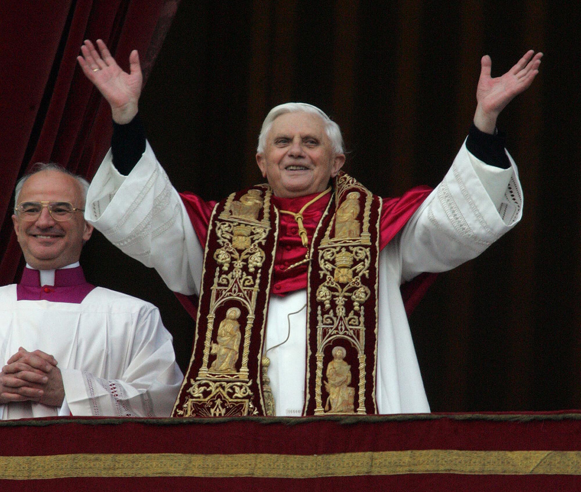 Then Pope Benedict XVI raises his hands to greet the crowd from St. Peter's Basilica moments after being elected.