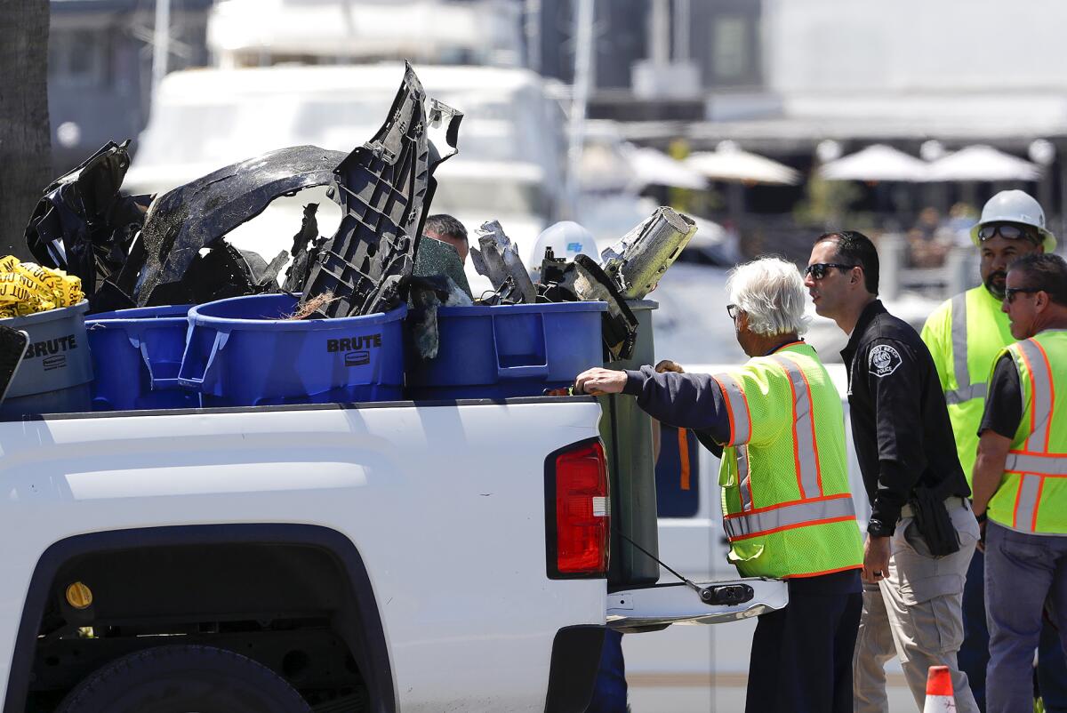 Pieces of car are loaded into the back of a truck