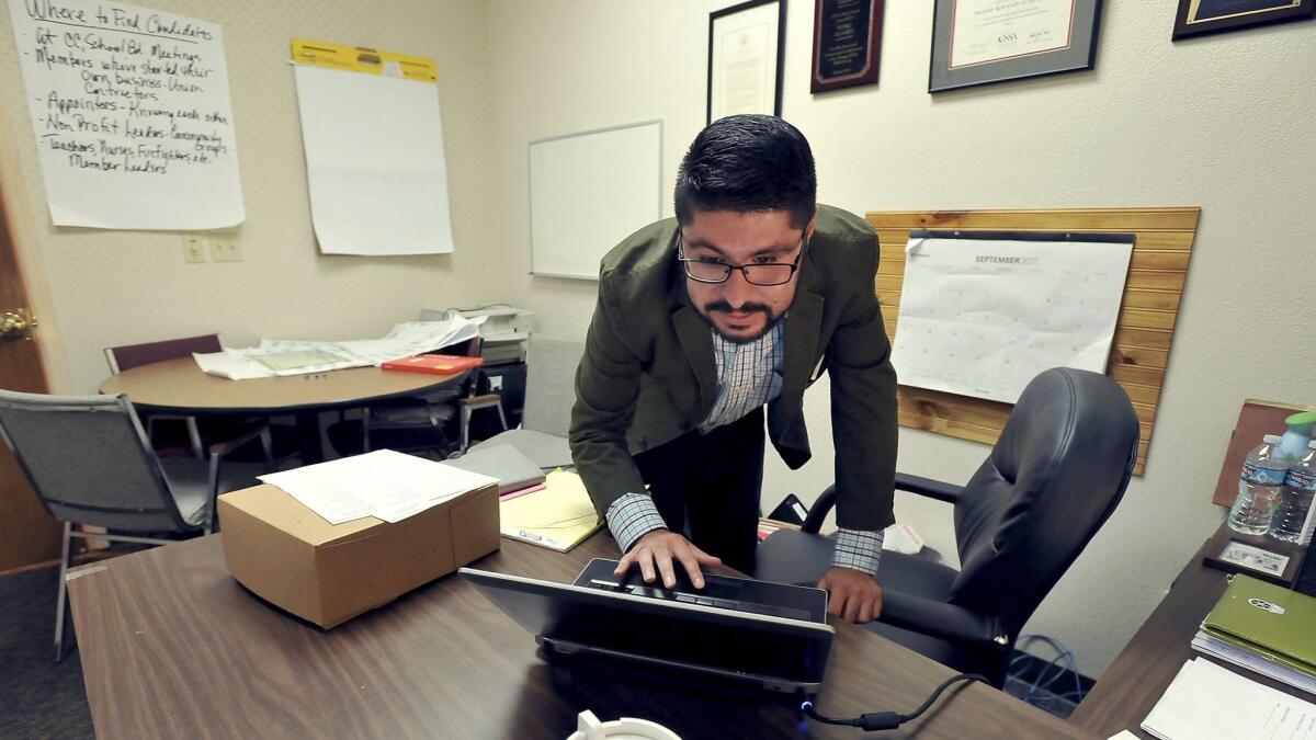 Pedro Ramirez, 28, checks his appointments while working in his office as a Central Valley field organizer for the California Labor Federation in Fresno. (Silvia Flores / For The Times)