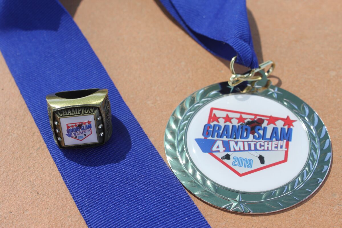 A Grand Slam 4 Mitchell Baseball Tournament ring and medal.