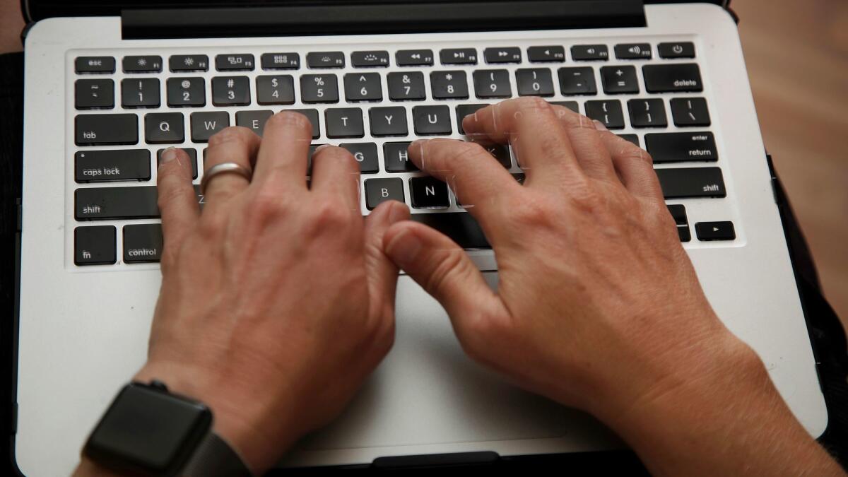 A person works on a laptop in North Andover, Mass on June 19.
