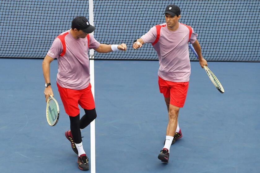 Bob Bryan, left, and Mike Bryan bump fists during their men's doubles quarterfinals match against Feliciano Lopez and Marc Lopez on Day 9 of the U.S. Open. The Spaniards won the match.