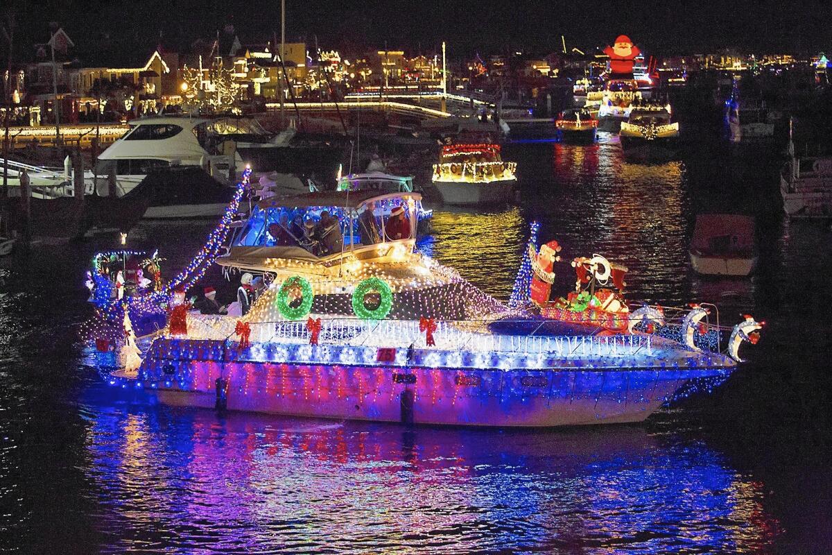 Colorful cruisers sail near the Balboa Bridge during the 107th Newport Beach Christmas Boat Parade at Newport Harbor in December.
