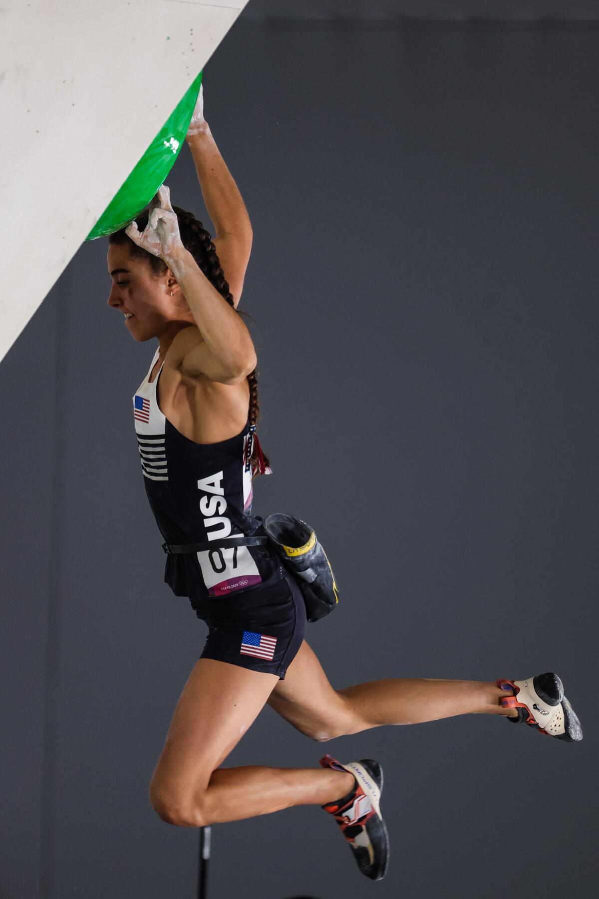 U.S. climber Brooke Raboutou dangles by her fingers after losing her grip during the bouldering final.