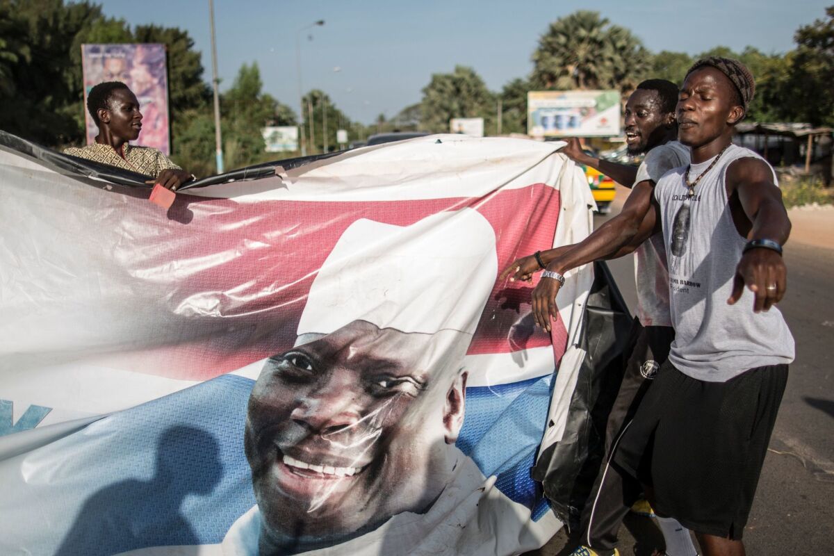 Supporters of Adama Barrow, the newly elected president of Gambia, tear down posters of the longtime incumbent Yahya Jammeh on Dec. 2 in Serekunda.
