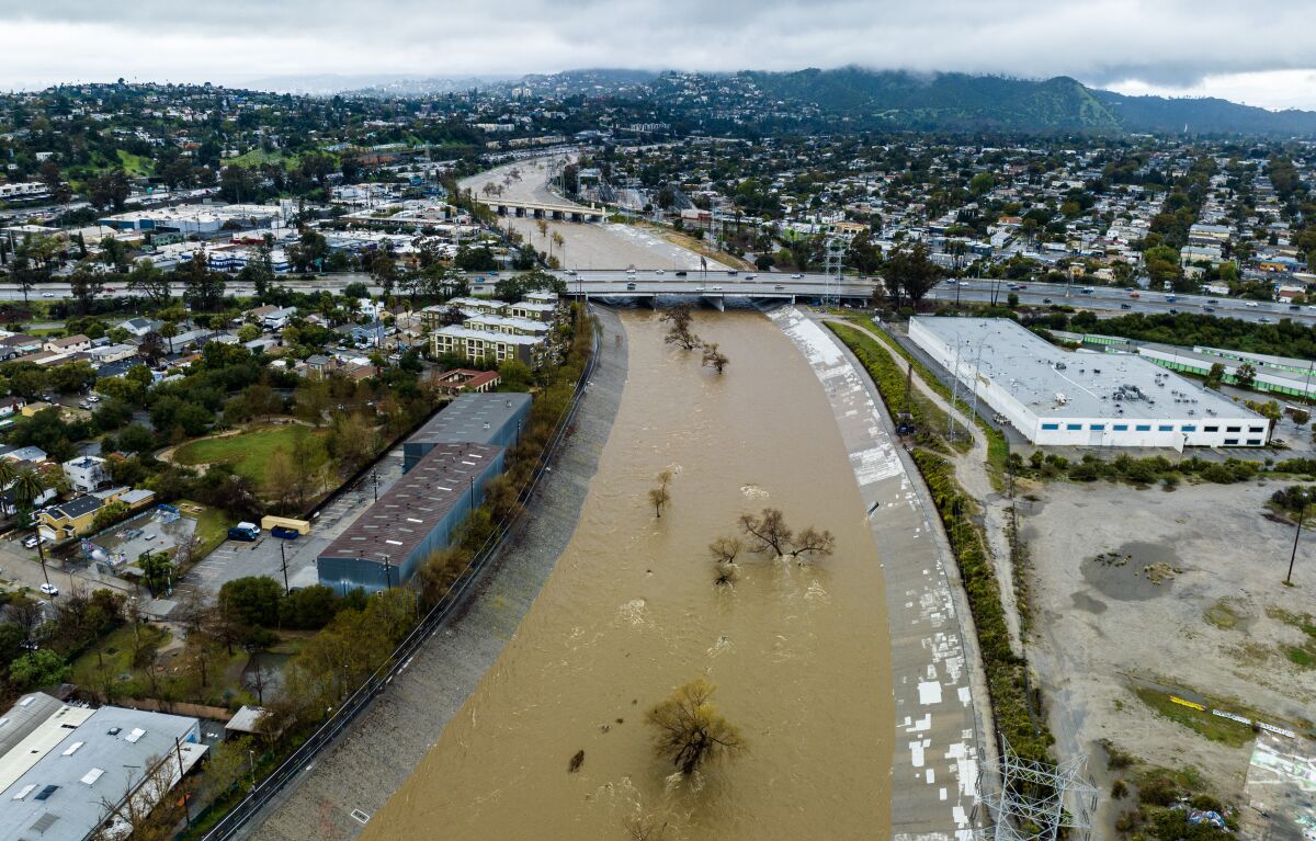 Muddy water in an uncharacteristically full and fast-moving Los Angeles River in the Frogtown neighborhood on Saturday.