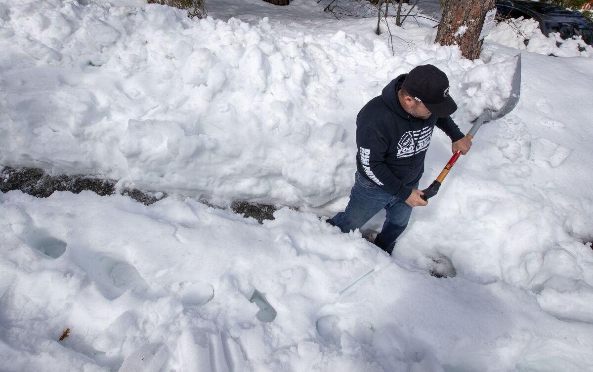 Sandals Church volunteer Dave Mack shovels a path through a lot of snow.