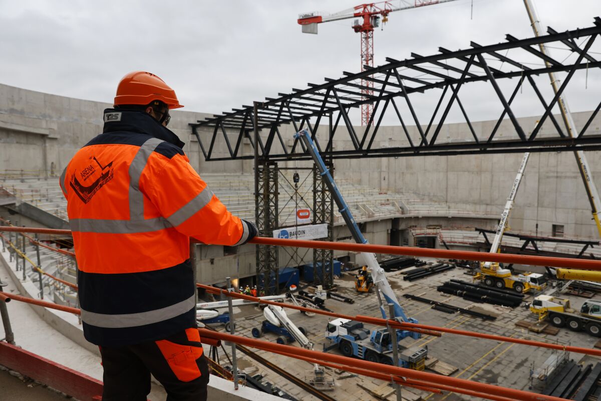 Un obrero observa la construcción de la Arena Porte de la Chapelle Arena, sede del bádminton y la gimnasia rítmica