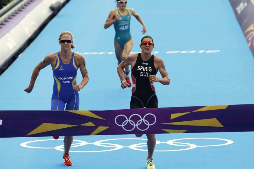Gold-medalist Switzerland's Nicola Spirig, right, silver-medalist Sweden's Lisa Norden, left, and bronze-medalist Australia's Erin Densham race to the Olympic triathlon finish line.