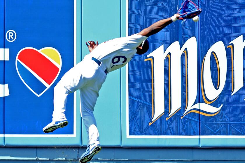 Dodgers outfielder Yasiel Puig can't make a leaping catch after losing the ball in the sun.