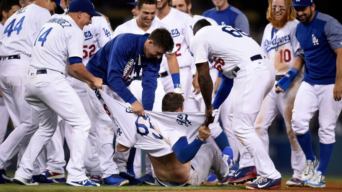 Kyle Farmer has his shirt ripped apart by teammates after hitting the game-winning double making his Major League debut against the San Francisco Giants.