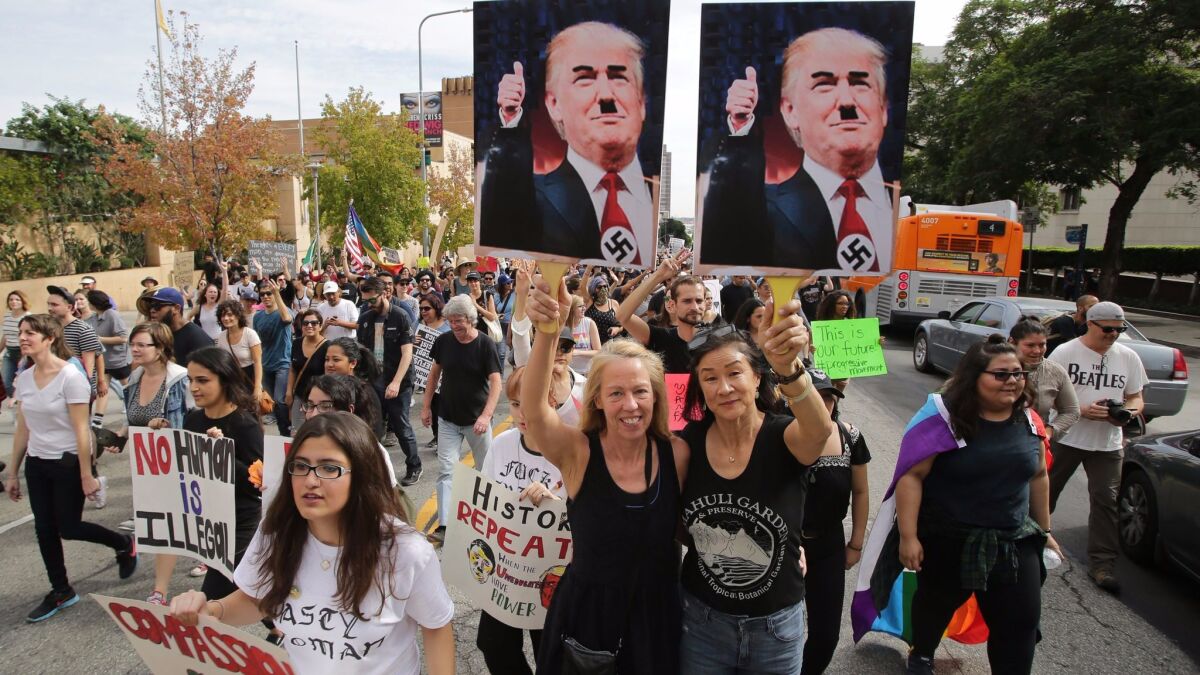 Demonstrators in Los Angeles hold placards depicting President-elect Donald Trump as Hitler, as thousands march in reaction to the presidential election results on Nov. 12.
