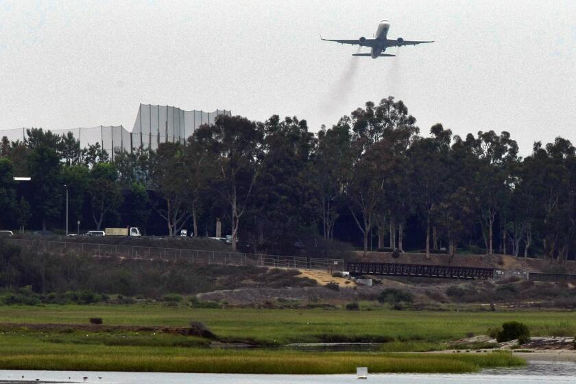 AUGUST 1, 2013. NEWPORT BEACH, CA. A commercial jet leaving John Wayne International Airport flies over the Upper Newport Bay Eco Preserve in Newport Beach, CA, on August 1, 2013. Pilots are being asked to fly over Newport Bay to reduce the noise over residential neighborhoods. (Don Bartletti / Los Angeles Times)