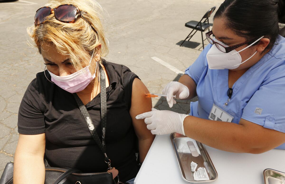 A woman gets a shot from a medical worker