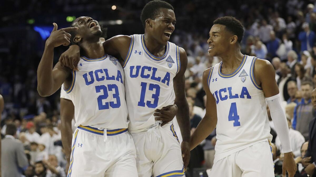 UCLA guard Kris Wilkes (13) celebrates after scoring the go-ahead basket with teammates Prince Ali (23) and Jaylen Hands (4) during a game against Notre Dame on Dec. 8. UCLA won 65-62.
