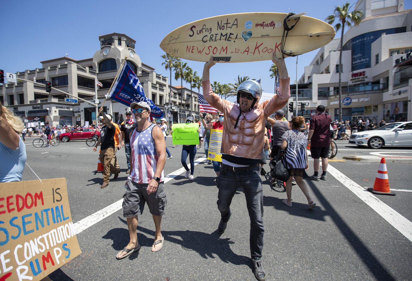 Protesters cross Pacific Coast Highway in Huntington Beach on Friday.