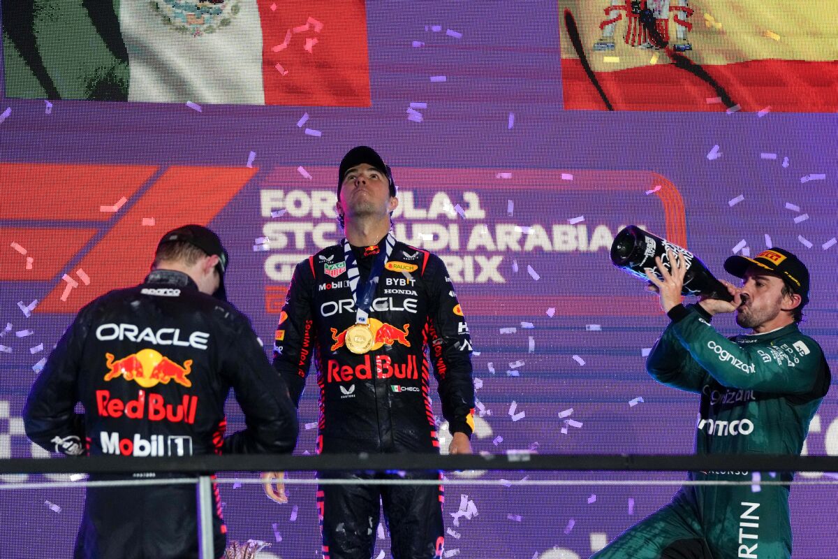 Red Bull driver Sergio Perez of Mexico celebrates after winning the Saudi Arabia Formula One Grand Prix with Red Bull driver Max Verstappen of the Netherlands, left, and Aston Martin driver Fernando Alonso of Spain, right, at the Jeddah corniche circuit in Jeddah, Saudi Arabia, Sunday, March 19, 2023. (AP Photo/Hassan Ammar)
