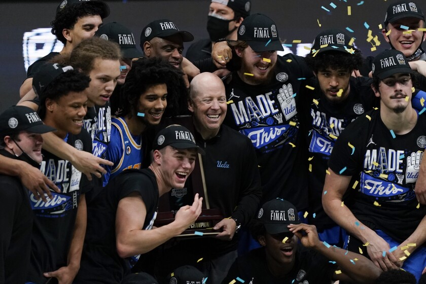 UCLA coach Mick Cronin celebrates with his players.