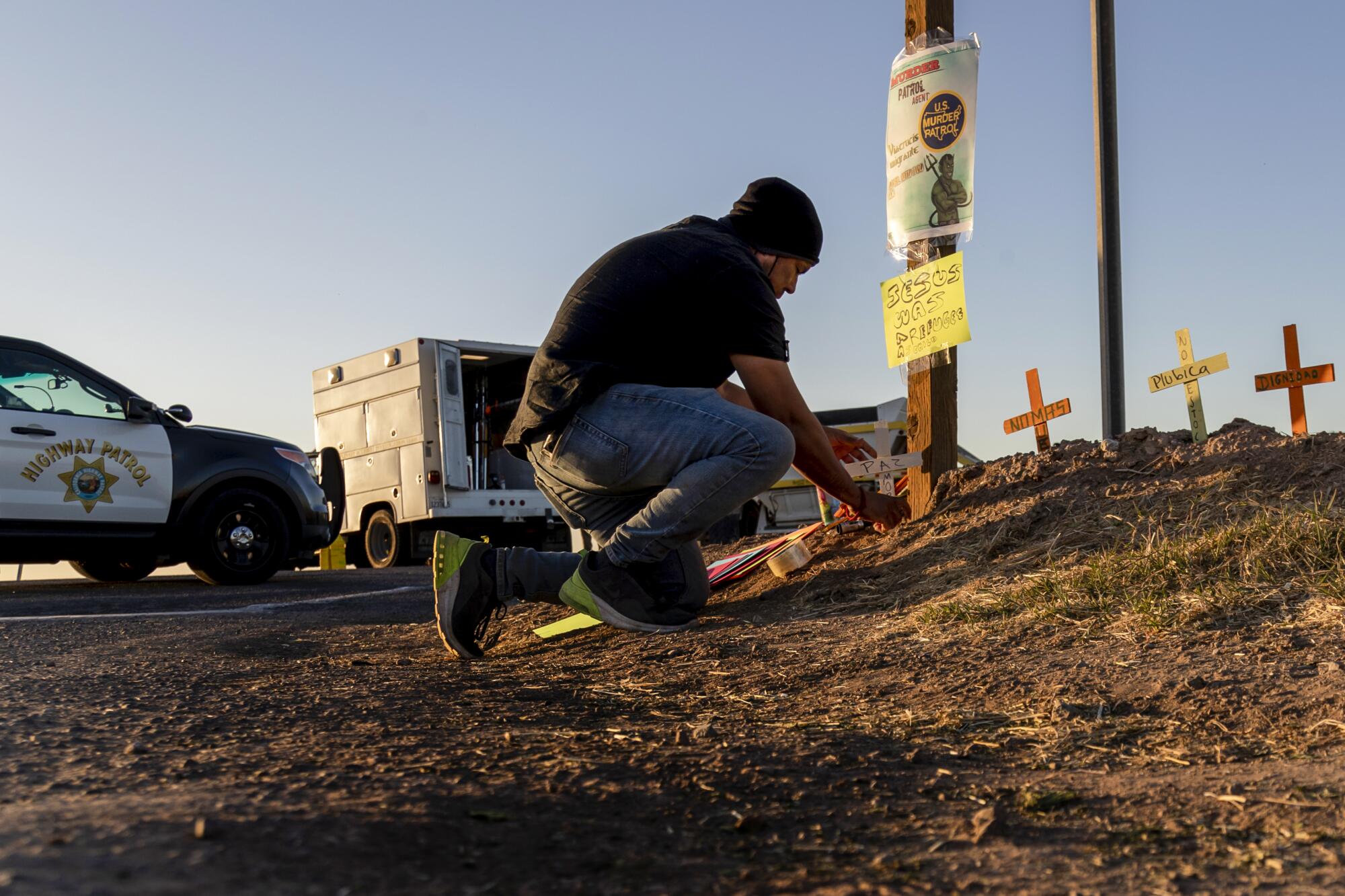 Activist Hugo Castro  places crosses at the scene of the fatal SUV crash near the border