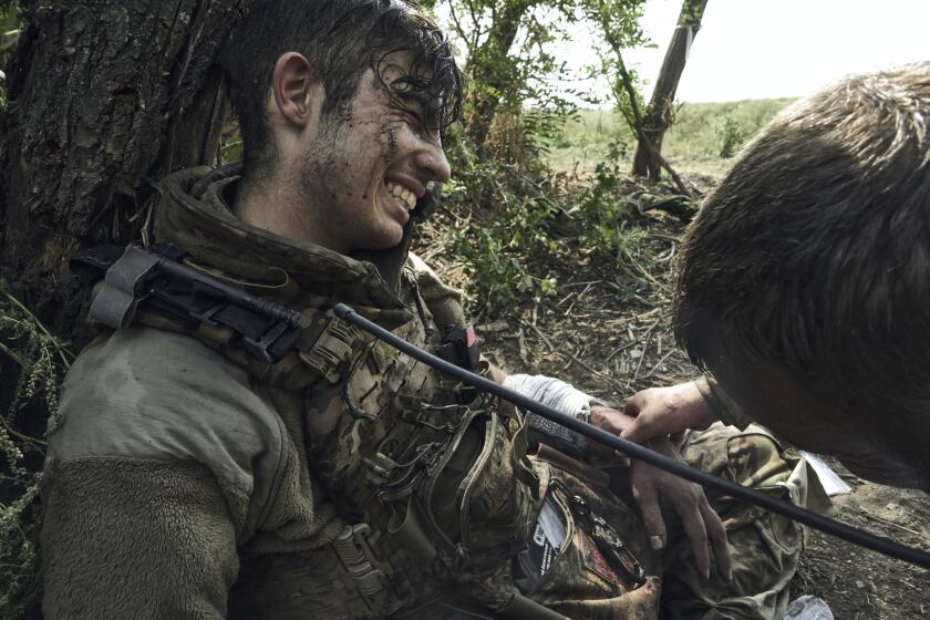 A soldier of Ukraine's 3rd Separate Assault Brigade gives first aid to his wounded comrade, call sign Polumya (Flame), 19, near Bakhmut, the site of fierce battles with the Russian forces in the Donetsk region, Ukraine, Monday, Sept. 4, 2023. (AP Photo/Libkos)