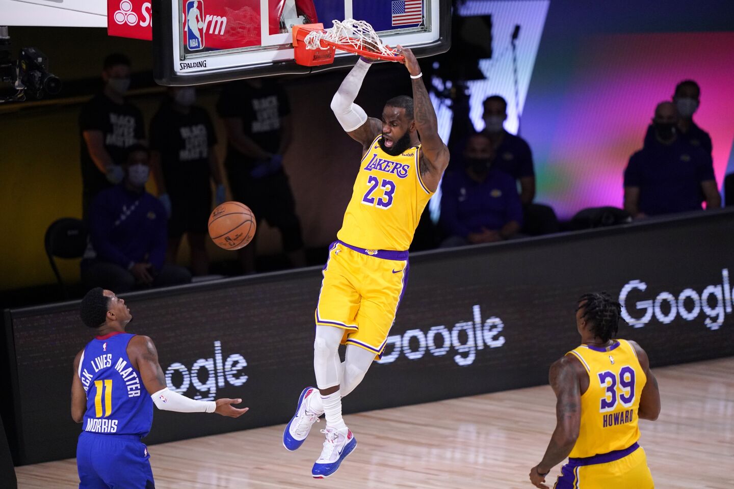 Denver Nuggets guard Monte Morris (11) and Los Angeles Lakers' Dwight Howard (39) look on as LeBron James.