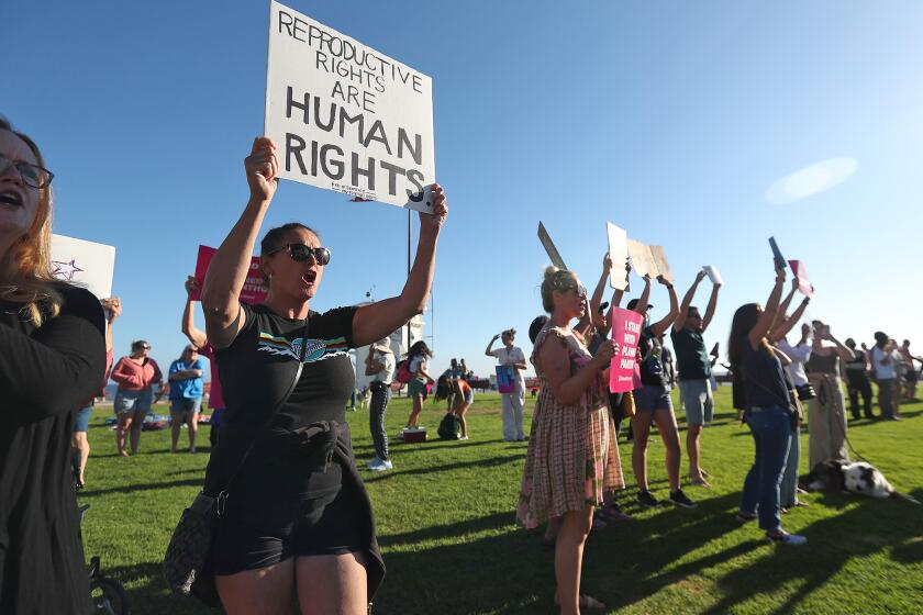 Protesters demonstrate the decision by the Supreme Court to overturn the Roe vs. Wade ruling during a Planned Parenthood protest at Main Beach in Laguna Beach on Friday.