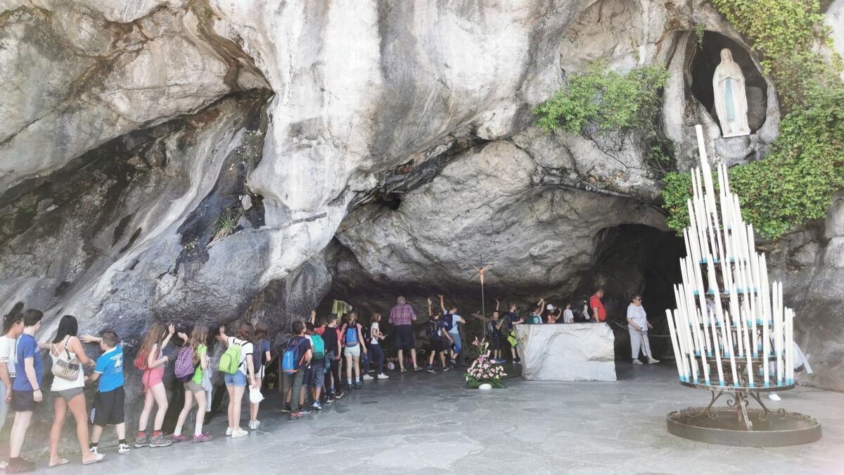 Tourists walk through the grotto where Bernadette said the mother of Jesus appeared to her in 1858.