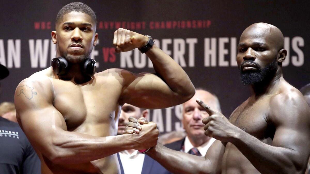 Heavyweight champion Anthony Joshua, left, and challenger Carlos Takam pose during the weigh-in at Motorpoint Arena in Cardiff, Wales, on Friday.