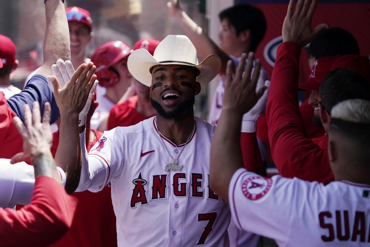 Angels left fielder Jo Adell is congratulated by teammates in the dugout after hitting a grand slam.